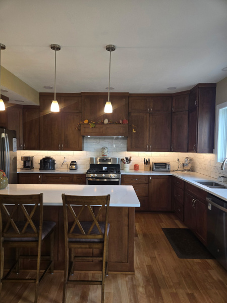 Kitchen with light cabinets, stainless steel refrigerator and gas range, tiled backsplash, and tiled floor